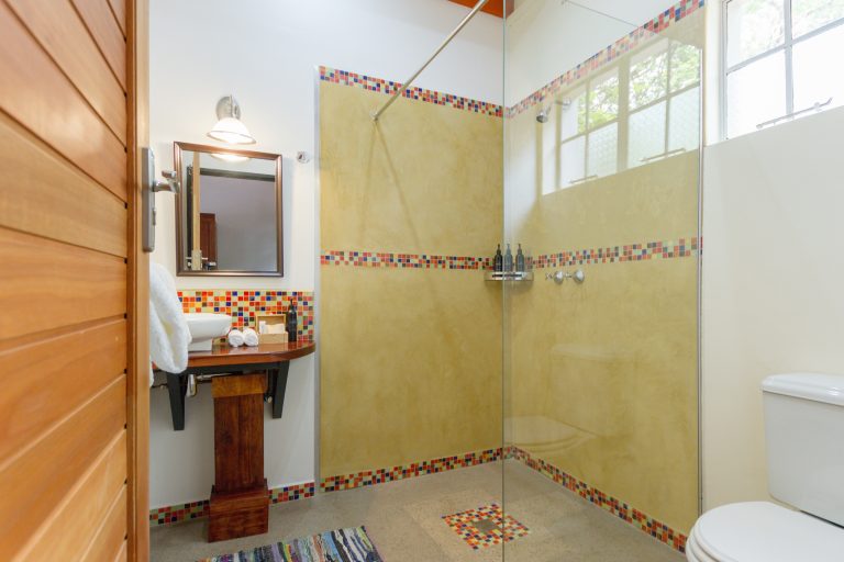 The bathroom features a shower and colourful tiles of room 8 at The Courtney Lodge