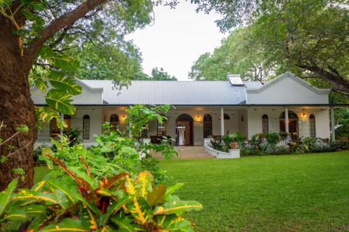 Green lawn and main building at at The Courtney Lodge, Victoria Falls